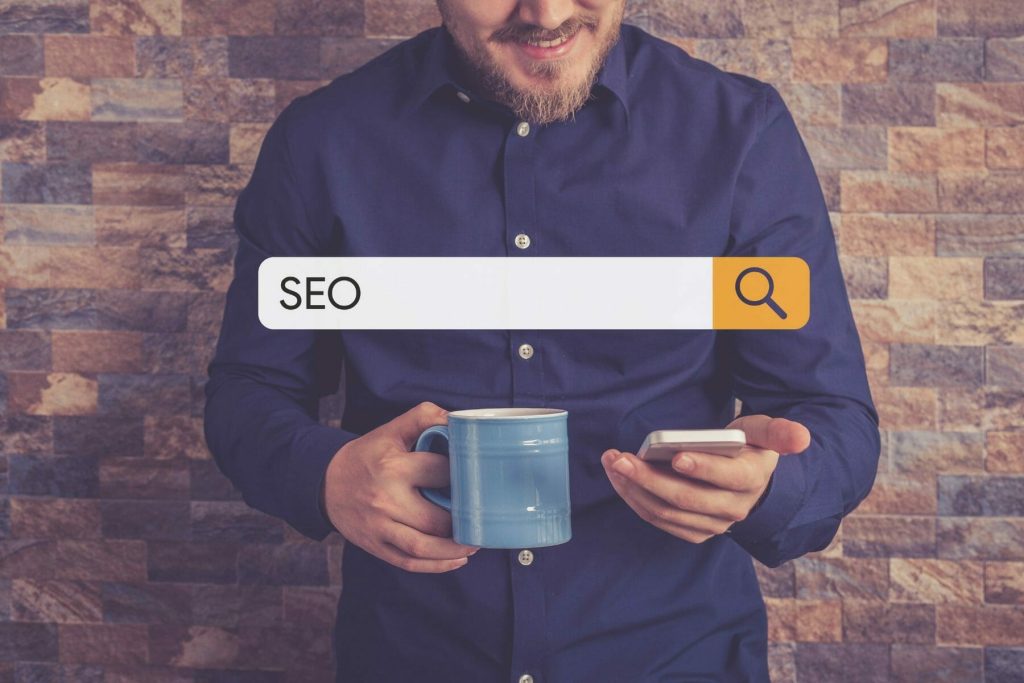 Bearded man searching the term SEO on his cell phone