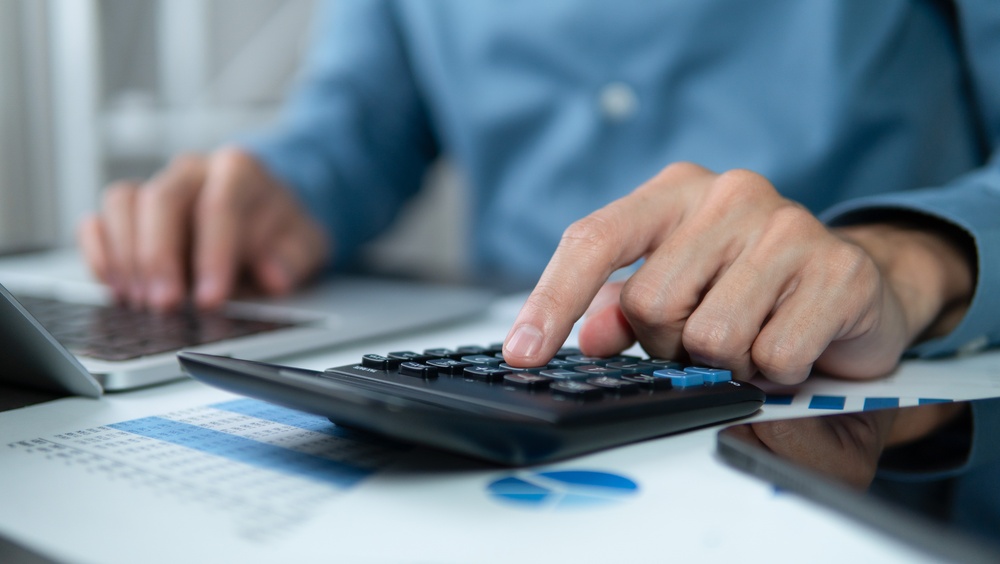Businessman using a calculator to check company finances